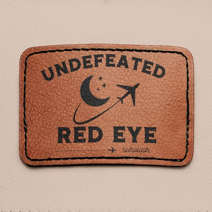 Close up of leather patch with "undefeated red eye survivor"
