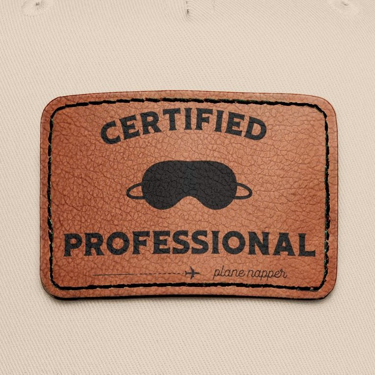 Beige and black  cap with a leather patch featuring "Certified Professional Plane Napper"