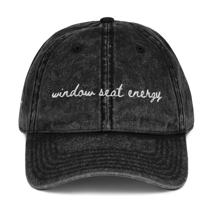 Vintage wash black travel hat with the words "window seat energy" embroidered on it